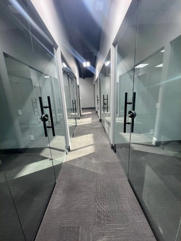Completed commercial office hallway with glass partitions